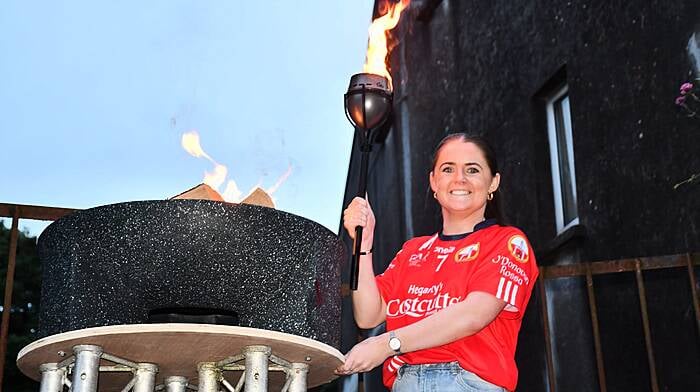 Lisa Harte, Captain of the O'Donovan Rossa ladies team who won the All Ireland Junior title in December  about to light the Skibbereen's  Olympic flame at the Arts Festival Street Party last Friday evening. Photo; Anne Minihane.