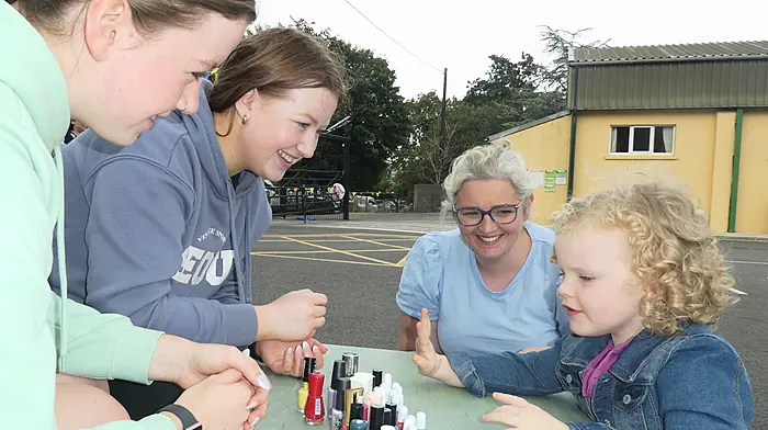 Nail artists Abbie and Amy Sheehan with Noelle Carey and little Grace Carey, carefully choosing her favourite colour – yellow - for her nails at the Gaggin summer barbecue.