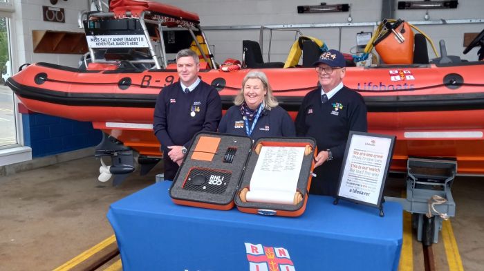 Nick Searls from the lifesaving operations team, Gail Swanton from fundraising and Gerard Quinn from water safety, all from Kinsale RNLI, signing the RNLI Scroll.