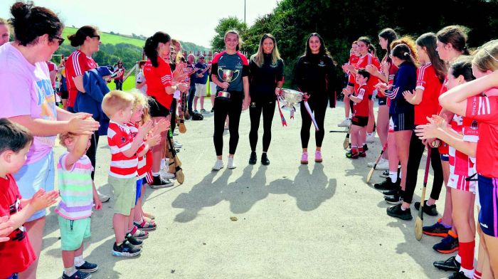 Grainne Hannon, Saoirse McCarthy and Fiona Keating being welcomed back to their local
club by enthusiastic younger Courcey Rovers players.