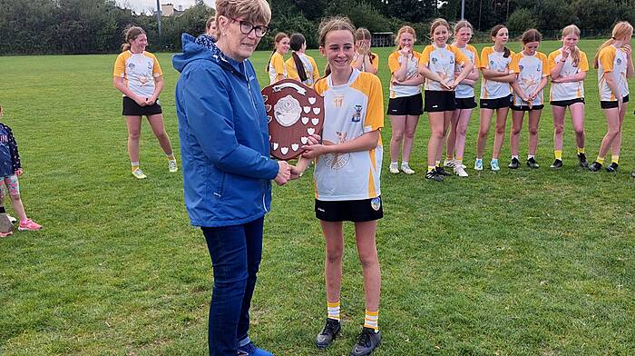 Aoife Fleming, captain of the Bandon U13 team, receiving the plate from Marie O’Donovan, sister of the late Kathleen O’Leary, in whose memory the Kathleen O’Leary memorial blitz was recently held at the Charlie Hurley park in Bandon.