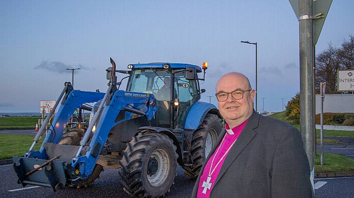 Bishop Paul Colton at Cork Airport takes a moment to watch the IFA, “Enough is Enough,” demonstration at Cork Airport this morning.