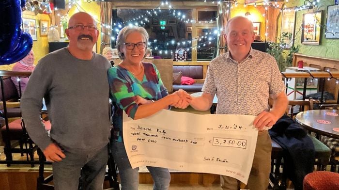 Deirdre Kelly, along with John Kelly, being presented with a cheque for €3,750 from GAA chairman Sean Dineen after she recently won the lotto jackpot.