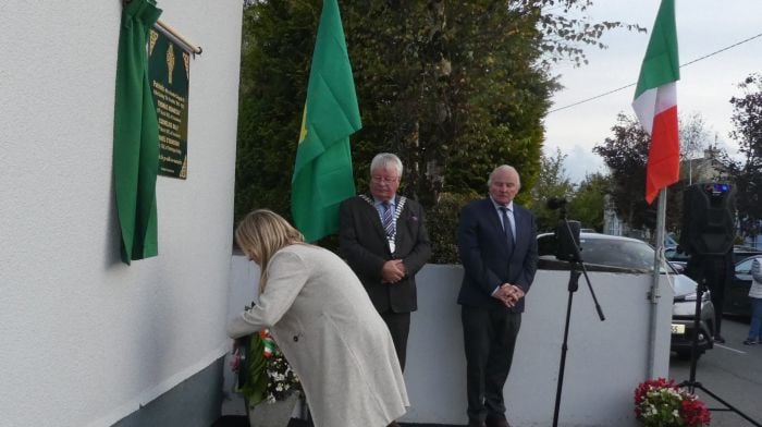 Helen O'Flynn Kiernan, principal of Clogagh National School,  laying a wreath at the newly unveiled plaque in remembrance of the three Clogagh patriots.  Also included in the photo are county mayor Cllr Joe Carroll and JJ Walsh.