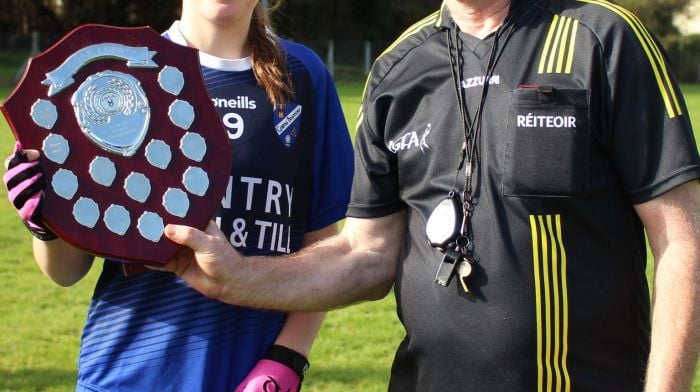 Sara Murphy, captain of the Bantry Blues U14 ladies, being presented with the county trophy by referee Kieran Creed after the Blues finished off the season in style by claiming the title.