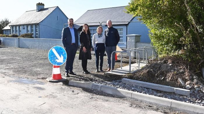 Christopher O’Sullivan TD, Catherine Foley (school principal), Betty Kenneally (board of management) and Sean Keohane (parents association) on the new footpath which is currently being constructed.  (Photo: Martin Walsh)