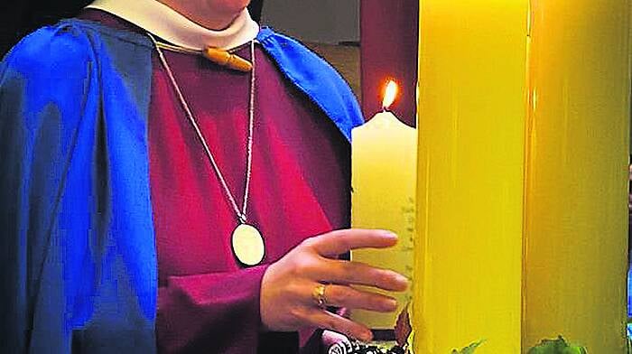 Sr Máire Bríd O’Driscoll from Enniskeane  lighting a candle at her recent solemn profession into the ‘Red Nuns’ (Sisters of the Holy Redeemer).