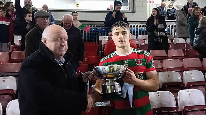 Noel O'Callaghan, vice chairman of Cork County Board, presenting the county junior A hurling trophy to Tracton’s captain Rory Sinclair last Saturday.