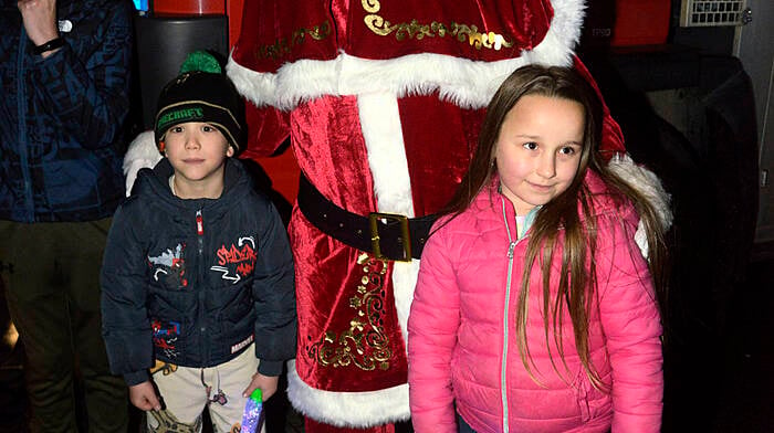 Waiting for Santa to switch on the lights recently in Bandon were Liam Tobance and Hanna Molnarr. Photo: Denis Boyle