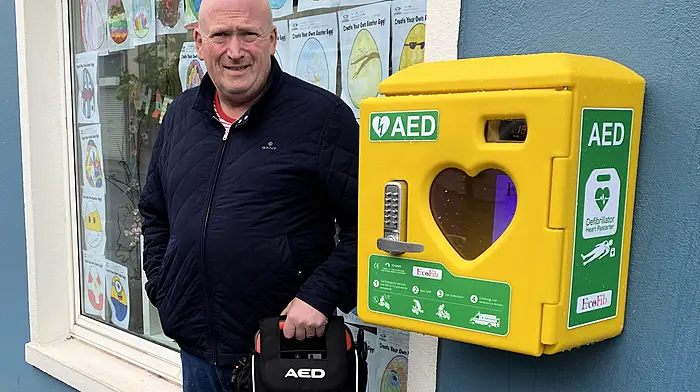 Barry Hennessy of Hennessy Transport Ltd placing the defibrillator into the AED unit at Drinagh Pharmacy, Ballineen.