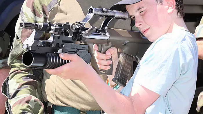 Young Tom O'Connor checking out the hardware at the Reserve Defence Force Display at Bandon Show, under the watchful eye of Corporal Kevin Buttimer, F Coy 12BN, Skibbereen. (Photo: Donie Hurley)