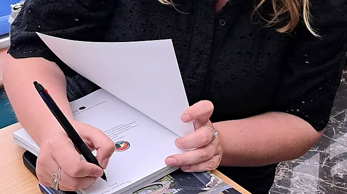 Shannon Forde signing copies of her latest book The Story So Far: 10 Years of the Lusitania Museum and Old Head Signal Tower.    (title of the book in italics)