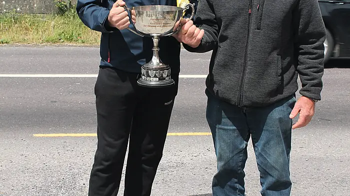 The Carbery U16 road bowling champion for 2025, Eoin Crowley from Dreenatra in Schull, receiving the winning cup from referee Diarmuid Herlihy.