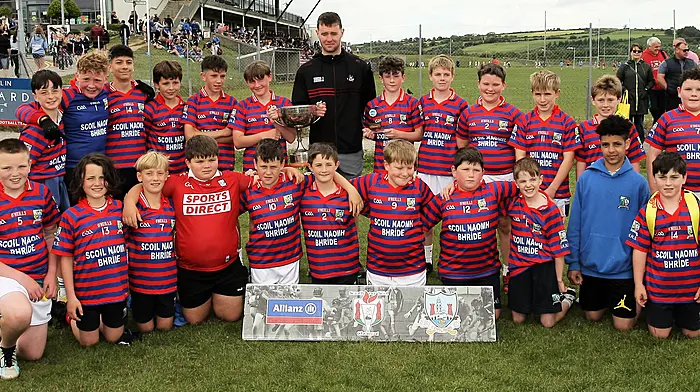 Roinn 4 Boys winners Union Hall NS receive the trophy from Cork footballer Maurice Shanley.