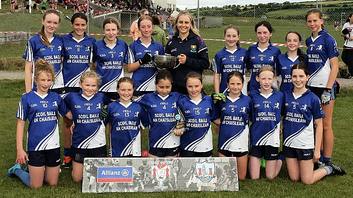 Roinn 3 Girls winners Castletownshend NS receive the trophy from Cork ladies footballer Laura O'Mahony. (Photo: Paddy Feen)