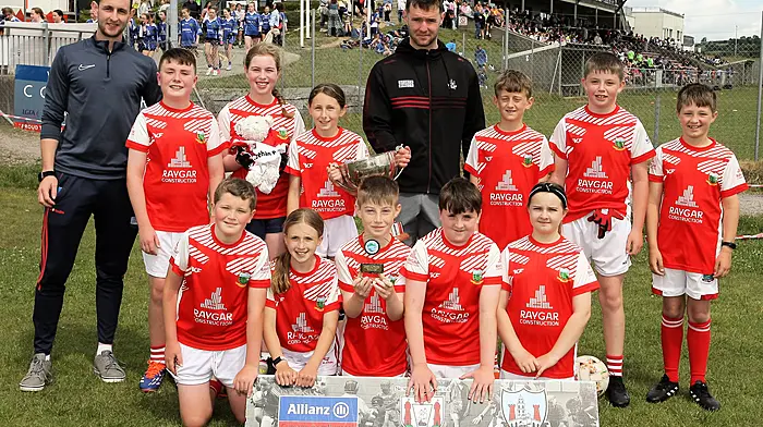 Roinn 10 Mixed winners Urhan NS receive the trophy from Cork footballer Maurice Shanley. (Photo: Paddy Feen)