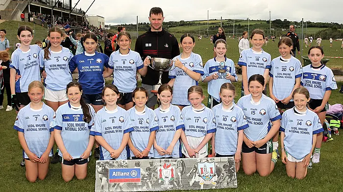 Roinn 4 Girls winners Scoil Mhuire NS Schull receive the trophy from Cork footballer Maurice Shanley. (Photo: Paddy Feen)