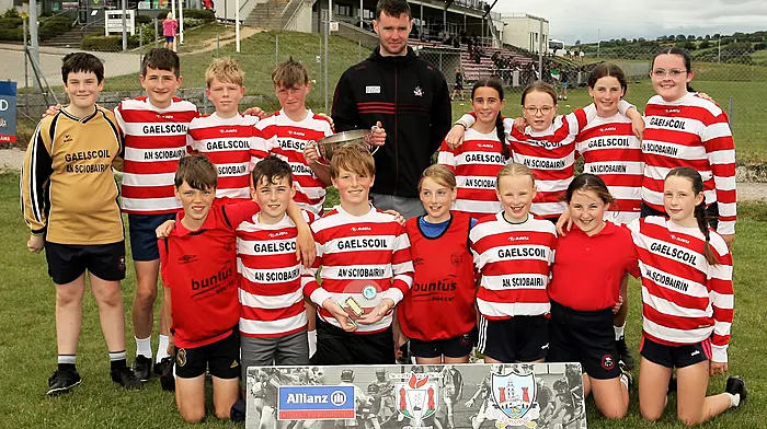 Roinn 7 Mixed winners Gaelscoil Dr Uí Shúilleabháin, Skibbereen receive the trophy from Cork footballer Maurice Shanley. (Photo: Paddy Feen)