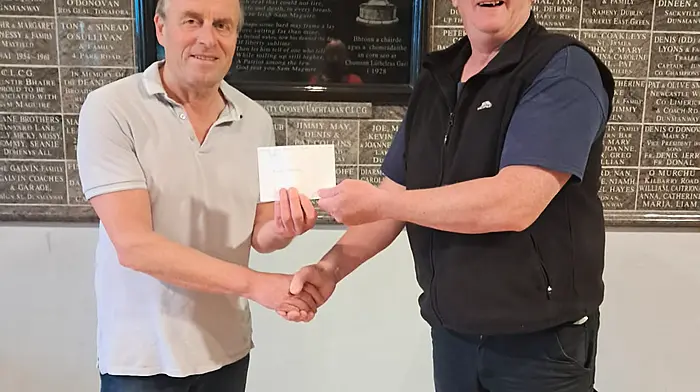 Barry Herlihy, winner of the Doheny lotto jackpot, being presented with a cheque of €3,800 from Doheny GAA chairman, Mark Farr.