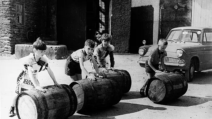 Boys rolling barrels onto the old wooden pier in Castletownbere for the salting of the fi sh during herring season, August 1967.