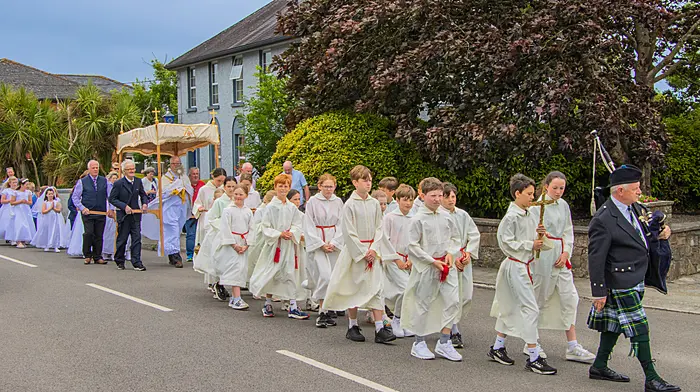 Piper Michael Heaney leading the Corpus Christi procession through Timoleague followed by altar servers, Fr John Kingston and parishioners.  (Photo: Gearoid Holland)