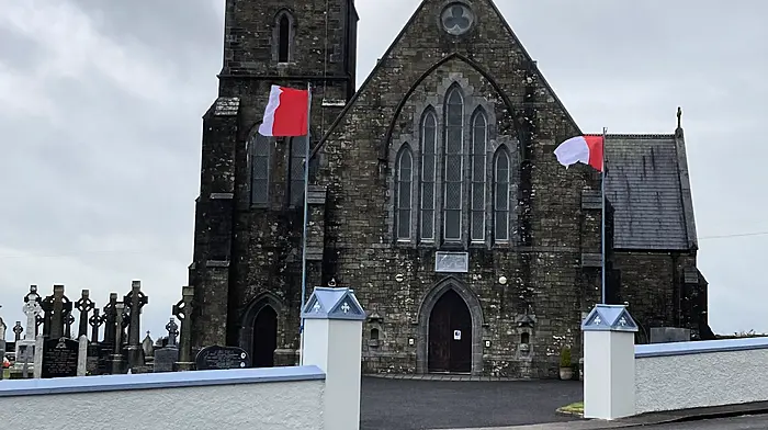 Two Cork flags outside St John the Baptist Church in Newcestown ahead of Sunday's All-Ireland hurling final.