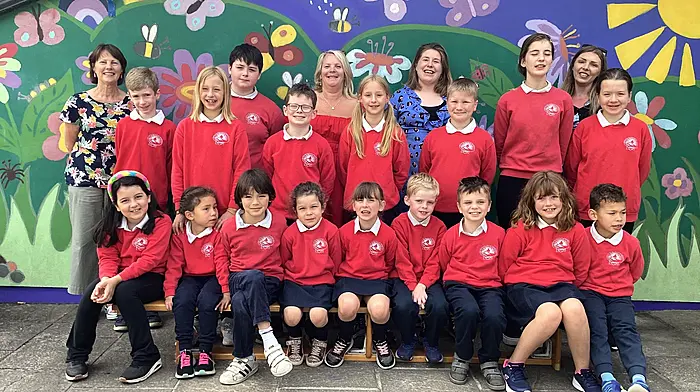 Clara McGowan with fellow staff members, Hannah Moynihan, Caroline Manning, Katie Buttimer and the pupils from Saint James' NS posing for one final photograph together before Clara retires as principal.