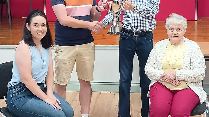 Pictured in Ballinascarthy Community Hall are the winners of the recent festival car treasure hunt Shauna and Vincent O'Flynn, being presented with the John O'Sullivan Memorial Cup by Kevin O'Sullivan and his mother Ann.