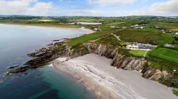 The Henrys’ former home was designed to take maximum advantage of beach views, above, and has a stunning deck, top, with Galley Head to its left.