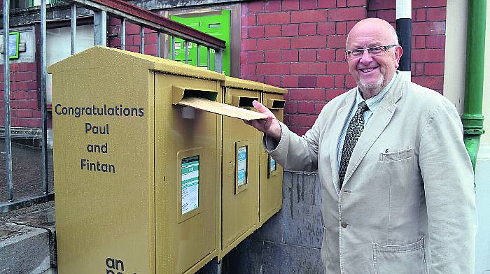 Adrian Healy, Skibbereen Post Office postmaster using the newly-painted gold post box at Skibbereen Post Office. (Photos: Anne Minihane)