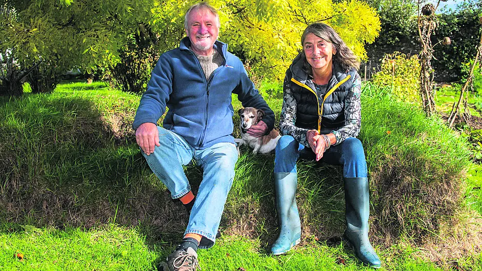Con McLoughlin and Karen Austin with ‘Tito’ on the ‘sod couch’ in their organic garden.                                        (Photos: Andy Gibson)