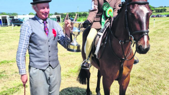 Judge Tim Hurley presenting Grace Wycherley from Skibbereen and ‘Caheragh Lad’ with the cup for Champion Working Hunter Pony at Belgooly Show.