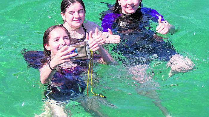 Katie Collins, Clíona O’Brien and Annie McCarthy catching up on their selfie collection using a waterproof dry bag for the mobile phone.(Photo: Anne Minihane)