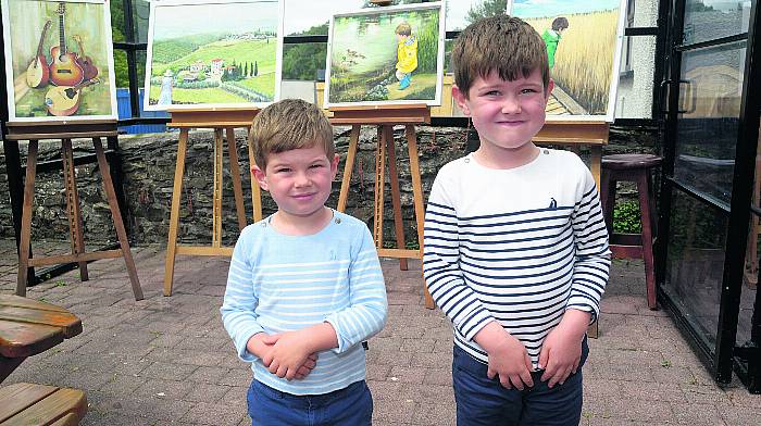 At the annual Gardens and Galleries festival at Innishannon were Iarla and Liam Walsh in front of paintings by their grandad, artist Gerry Larkin. (Photo: Denis Boyle)