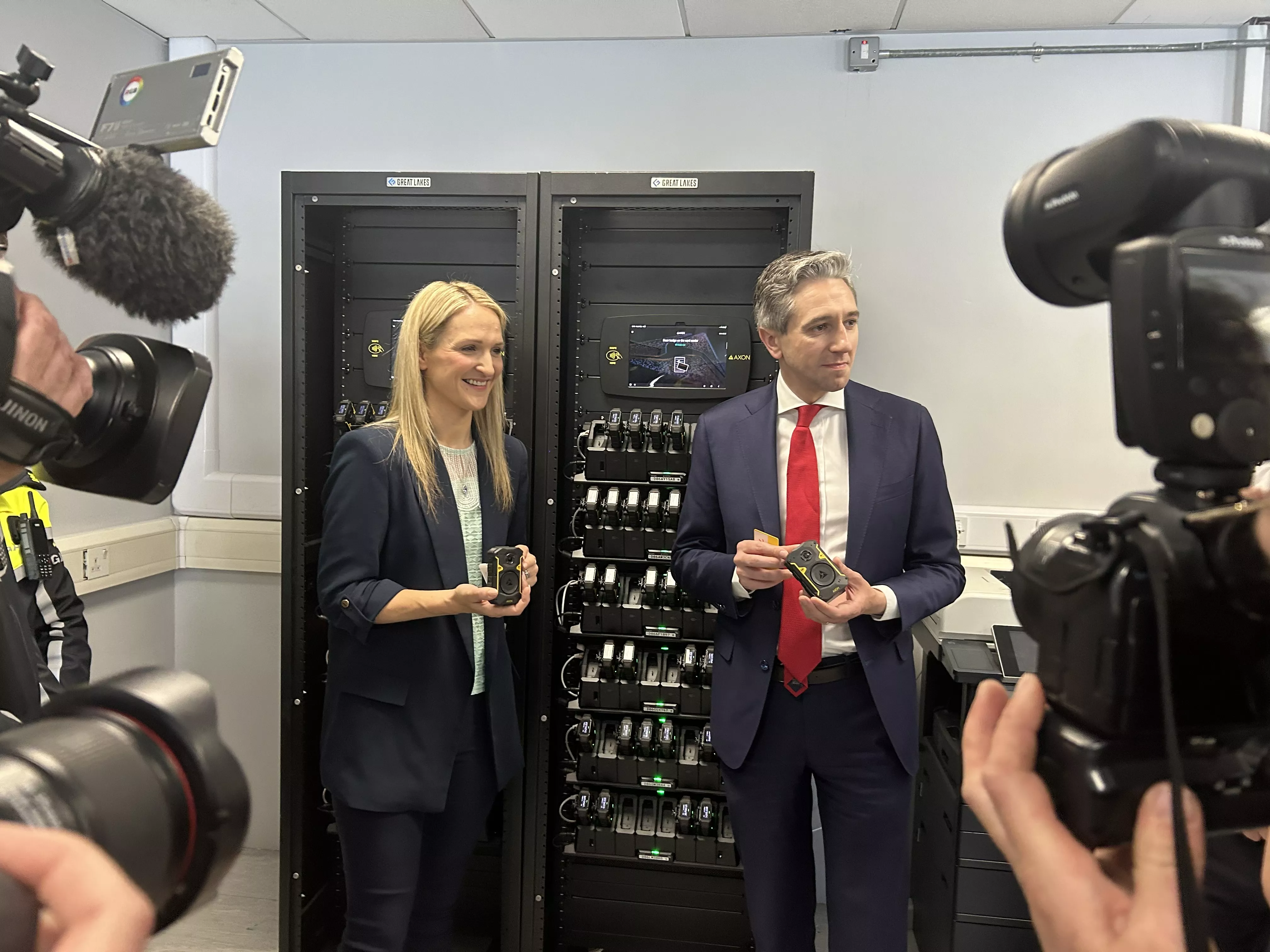 Justice Minister Helen McEntee and Taoiseach Simon Harris near a bank of bodycams at Store Street Garda Station 