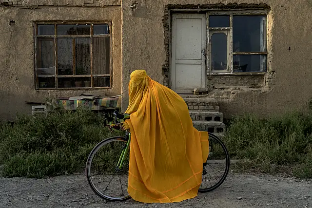 A woman in a burqa on a bike