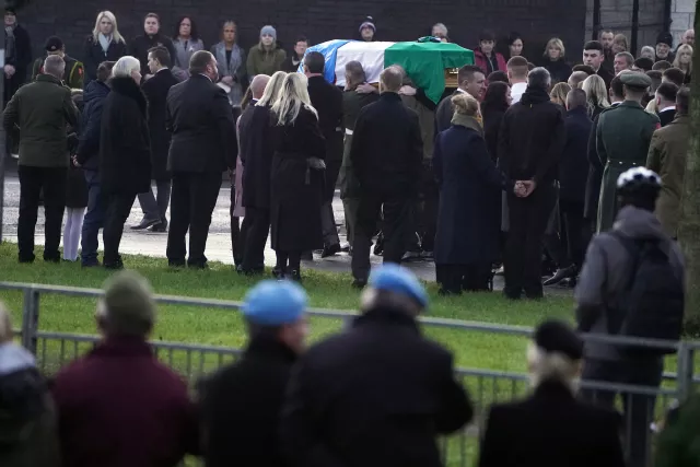 The coffin of Private Sean Rooney is carried into Holy Family Church