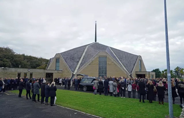 Mourners arrive at the church