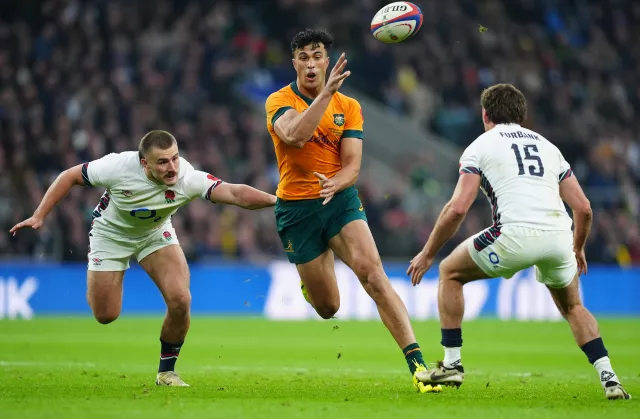 Australia’s Joseph Sua'ali'i, centre, throws a no-look pass under pressure from England’s Ollie Sleightholme, left, and George Furbank