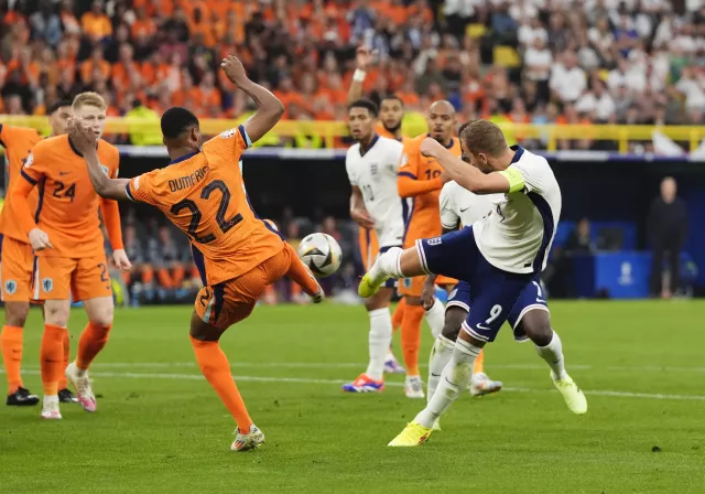 Dumfries challenges Kane in the penalty area