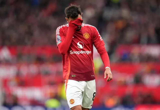 Manchester United captain Bruno Fernandes covers his face after being sent off