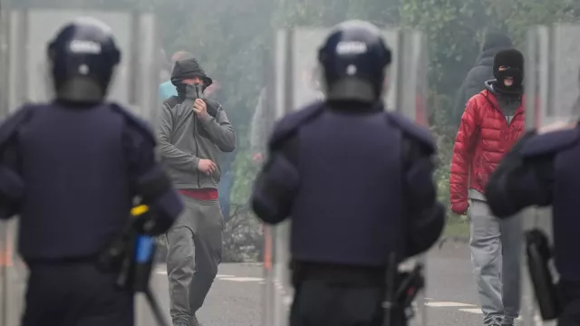 Gardai face masked protesters