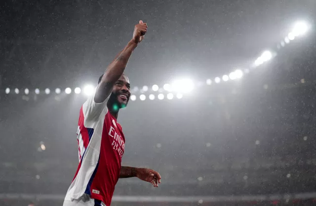 Raheem Sterling raises his right hand to celebrate scoring for Arsenal against Bolton